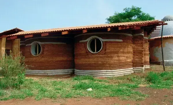 Bioconstrução: casa com superadobe e janelas redondas