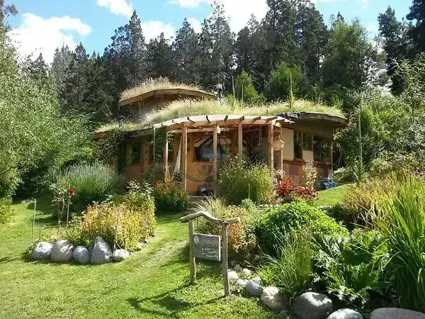 Bioconstrução: casa com telhado verde e vegetação ao redor