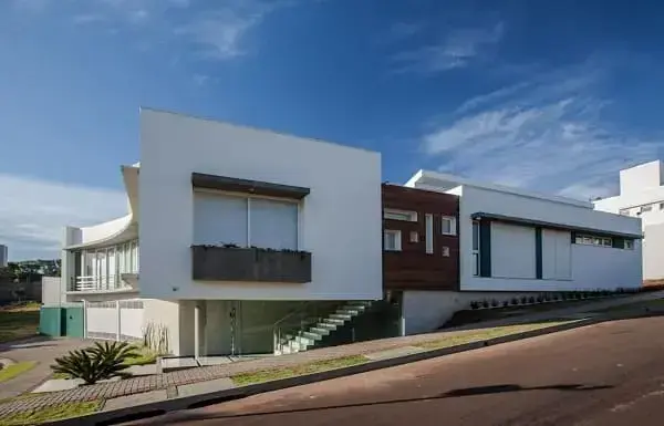 Fachadas de casas térreas modernas: Fachada com acabamento de madeira (projeto: João Vitor Ricciardi)