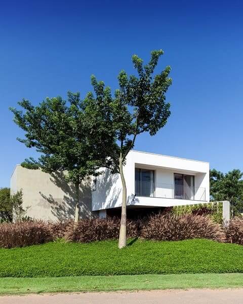 Casa quadrada: fachada branca integrada com a natureza (projeto: Consuelo Jorge)