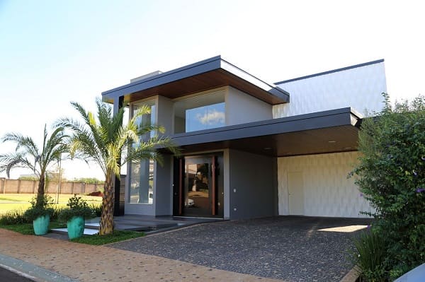 Casa quadrada: fachada com parede de vidro e vasos verdes (projeto: Belezini + Dalmazo Arquitetura)