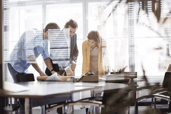 Métricas para escritório de arquitetura: Profissionais em sala de reunião discutindo sobre projeto (fonte: adobestock)