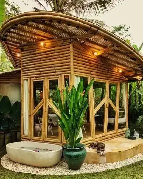 Casa de bambu: chalé com porta de vidro e iluminação na cobertura