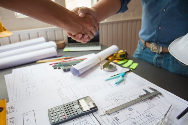 Profissional fechando negócio sobre mesa de trabalho