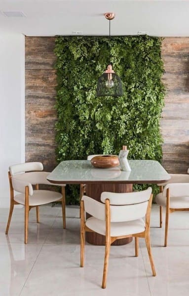 Muro verde em varanda com mesa de madeira (foto: Revista Viva Decora)