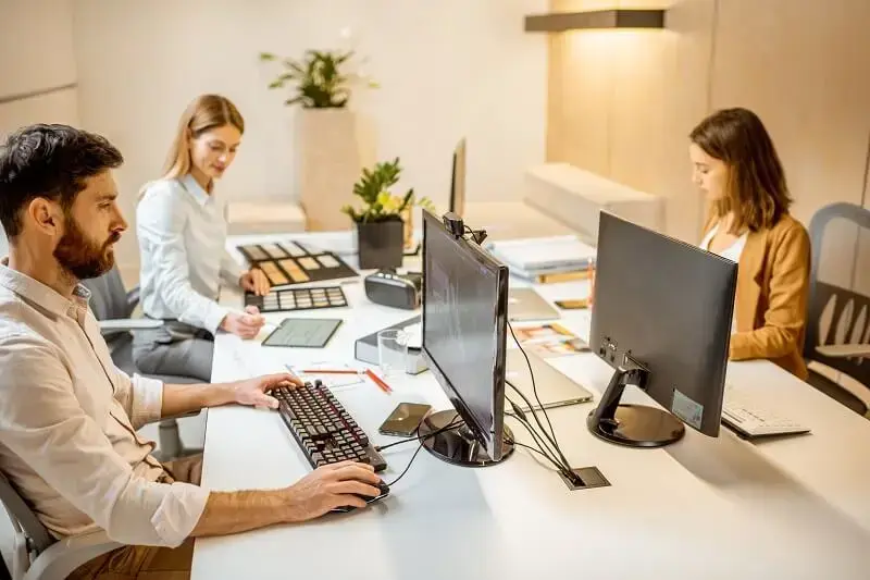 Software de gestão: arquitetos trabalhando juntos sobre mesa no escritório.