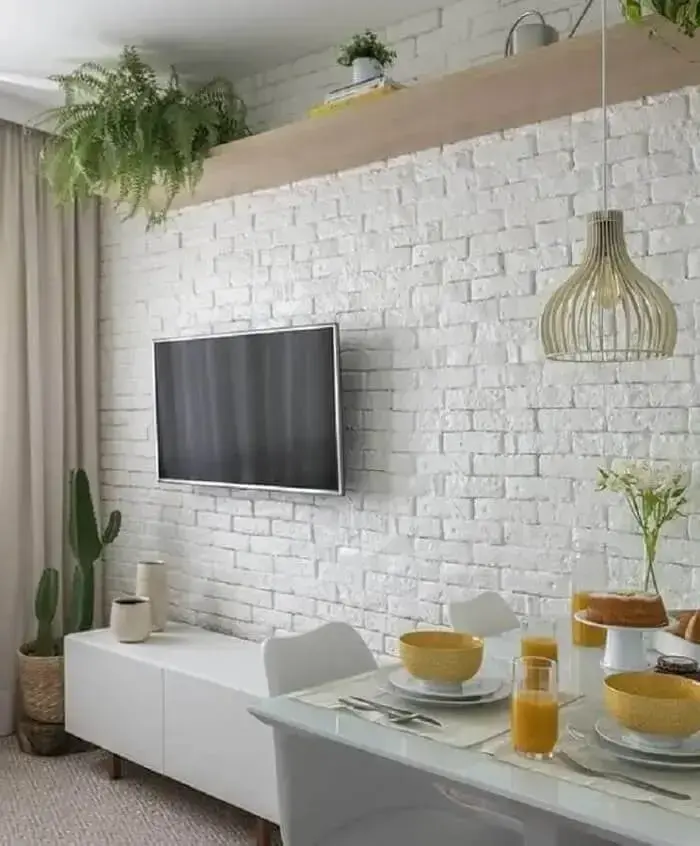 Decoração clean para sala pequena com parede de tijolo de gesso. Foto: Jeito de Casa