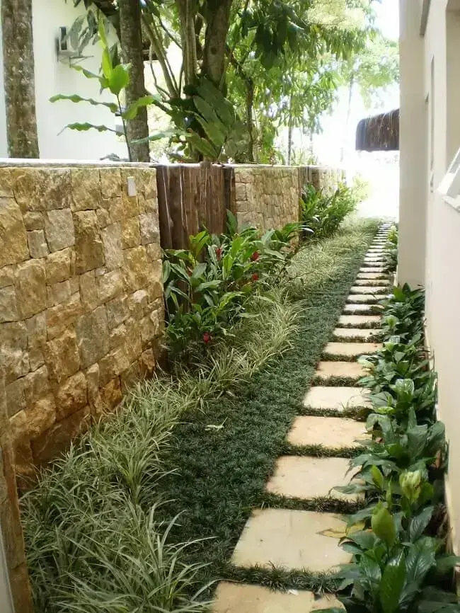 As pedras naturais e vegetação natural escolhida formam uma combinação perfeita nesse projeto de paisagismo residencial