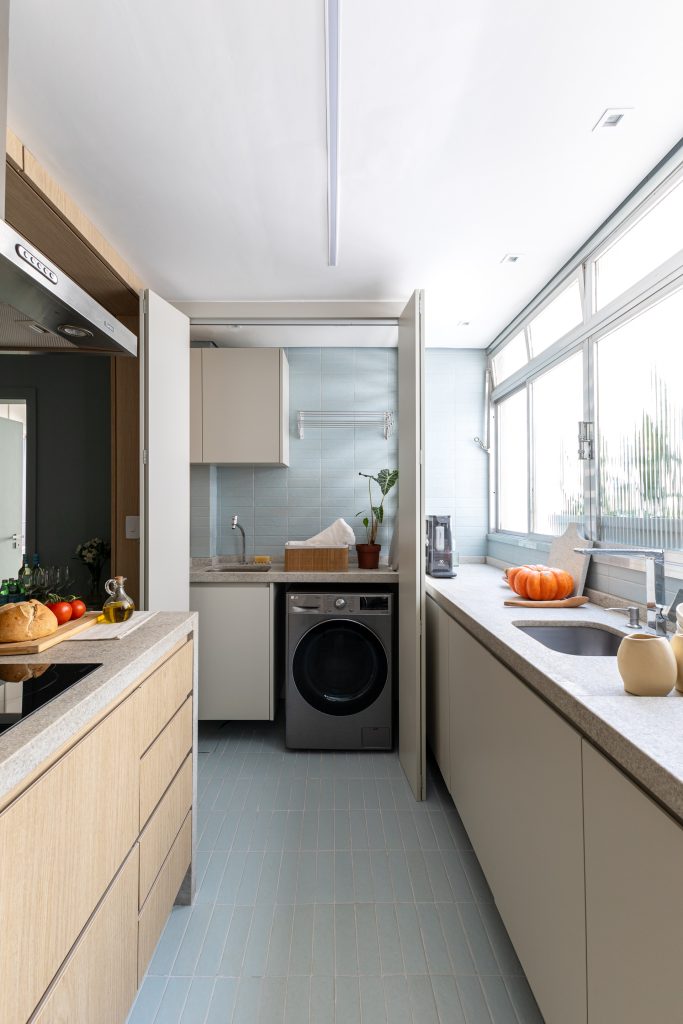Projeto: Bima Arquitetura | A cozinha com novo layout reorganiza os ambientes, inserindo a lavanderia oculta dentro de um armário.