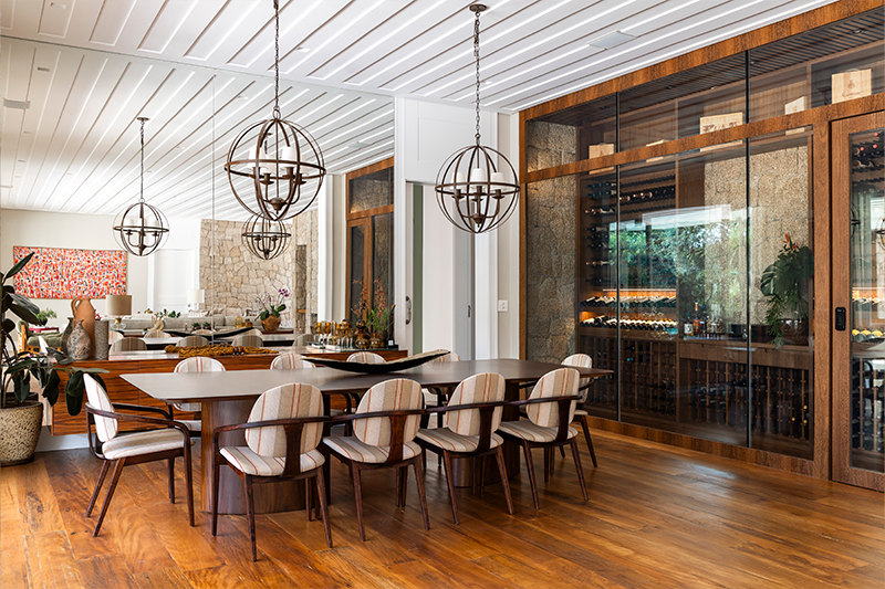 Projeto: Rogério Luciani | Sala de jantar integrada, com adega em vidro e madeira que valoriza a sofisticação do estilo toscano.