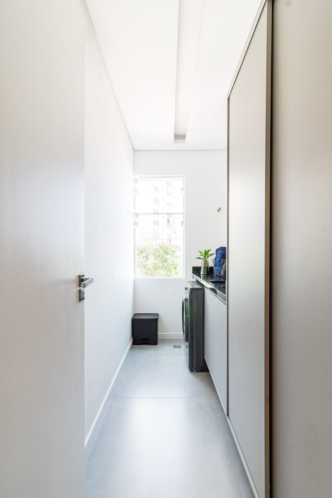 Projeto Bimá Arquitetura | A antiga cozinha se transforma em lavanderia, criando uma área de serviços funcional e integrada ao conceito do apartamento