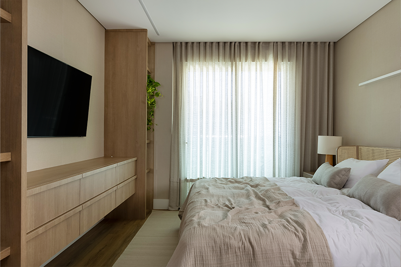 Projeto: Bo. Arch Studio | No quarto de casal, a marcenaria em madeira clara e a paleta neutra criam um espaço acolhedor e relaxante.