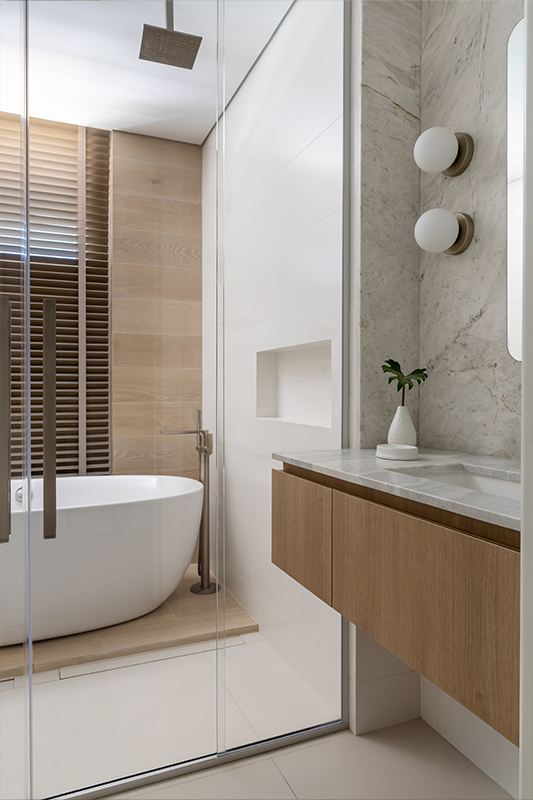 Projeto: Bo. Arch Studio | banheiro da suíte combina mármore, madeira e linhas minimalistas, com destaque para a banheira independente que reforça a atmosfera de relaxamento.