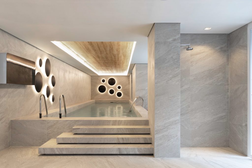 Projeto: Bo.arch | O SPA, a piscina e a presença marcante da luz natural criam uma atmosfera de pausa e aconchego, onde texturas, cores e mobiliário se unem para compor experiências únicas aos moradores.
