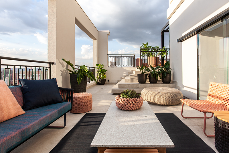 Projeto: Daiane Antinolfi | O lounge externo proporciona vista privilegiada da cidade e mobiliário em corda náutica, com paleta que mescla azul-marinho e rosa.