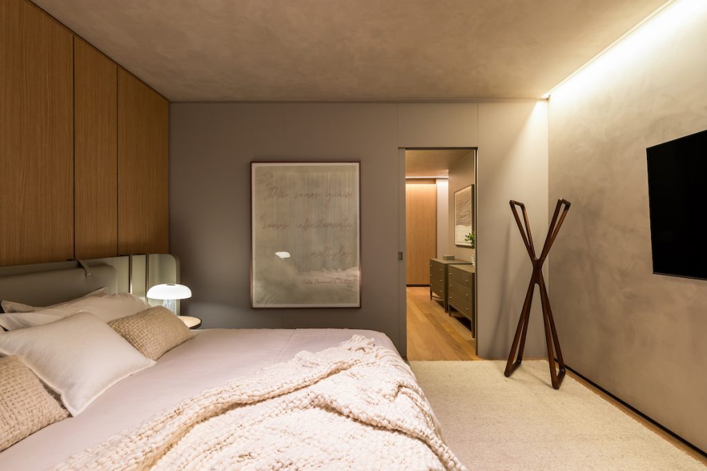 Projeto: Bo.arch Studio | O quarto com as paredes em cimento queimado traz um refúgio acolhedor ao ambiente.