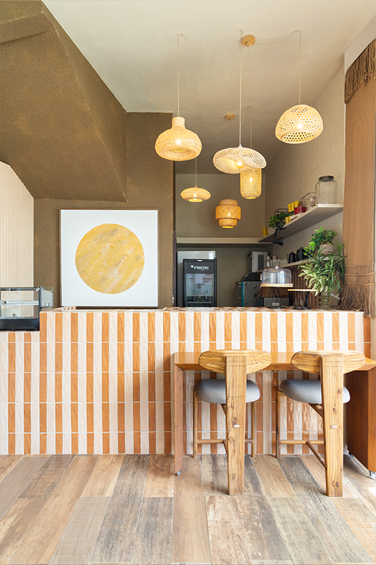 Projeto: Rodrigo Coelho | Mostra Morar Mais 2025 | O destaque do projeto está na paleta de tons terrosos, que contrasta propositalmente com o azul do mar e o branco da fachada, criando um diálogo harmônico entre terra e água.