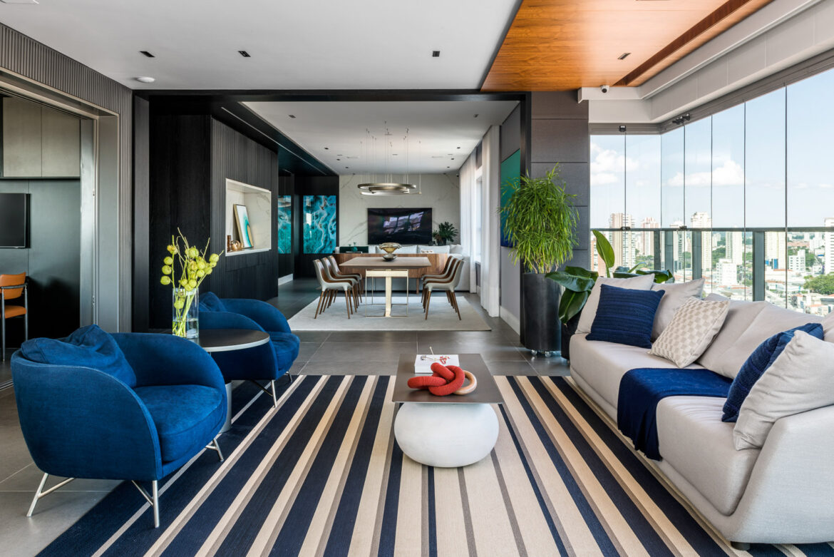 Projeto une elegância e personalidade com varanda gourmet, sala de TV e pórtico preto na entrada do local