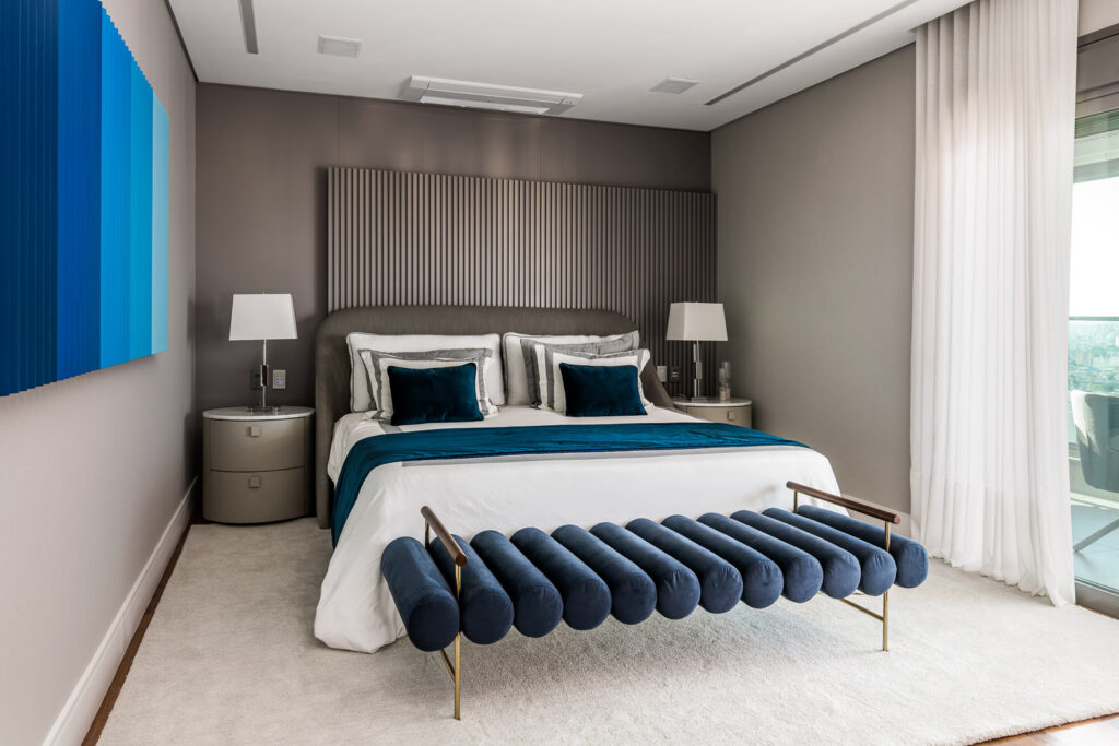 O quarto em tons de cinza e azul-marinho, acrescentam personalidade ao ambiente.