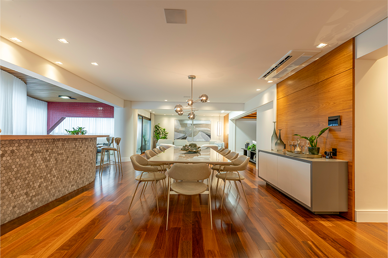 Design clean e mobiliário minimalista compõem uma sala de jantar integrada visualmente à área social.