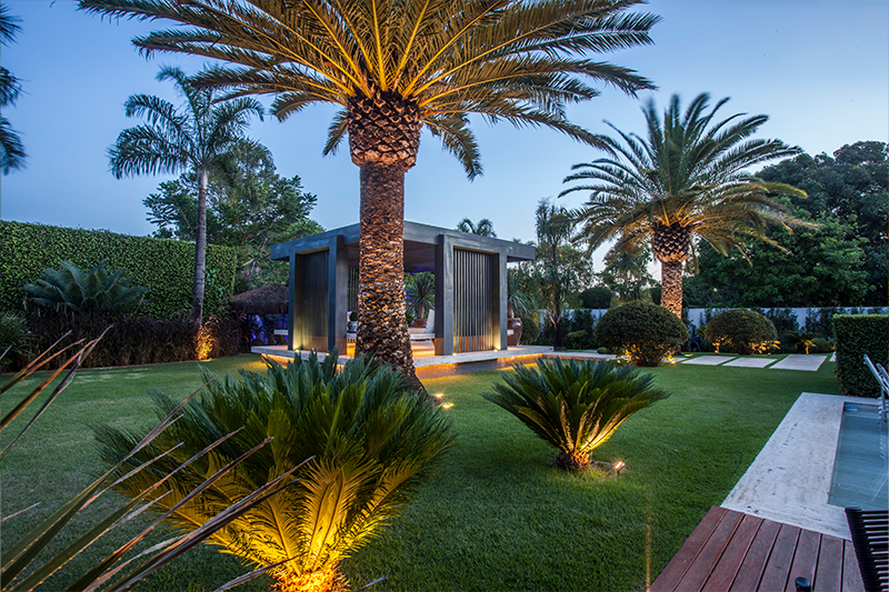 Projeto de arquitetura: MAAI Arquitetura | Mais um exemplo que mostra espécies de alturas diversas convivendo em harmonia em torno da piscina, como as palmeiras Canarienses e as Cycas.