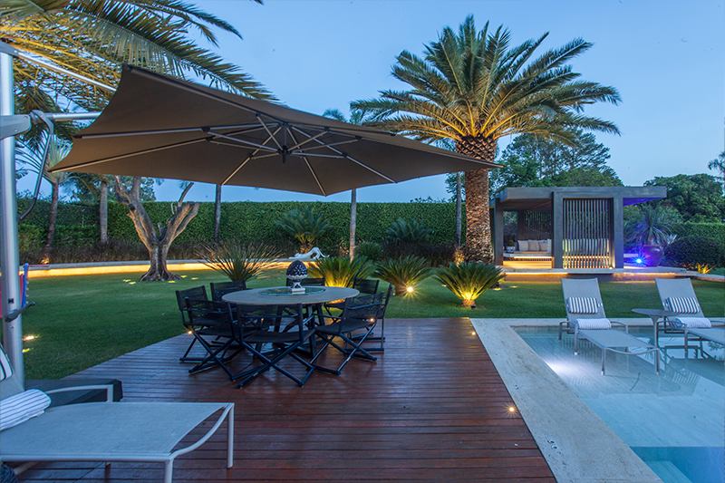 Projeto de arquitetura: MAAI Arquitetura | Mais um exemplo que mostra espécies de alturas diversas convivendo em harmonia em torno da piscina, como as palmeiras Canarienses e as Cycas.