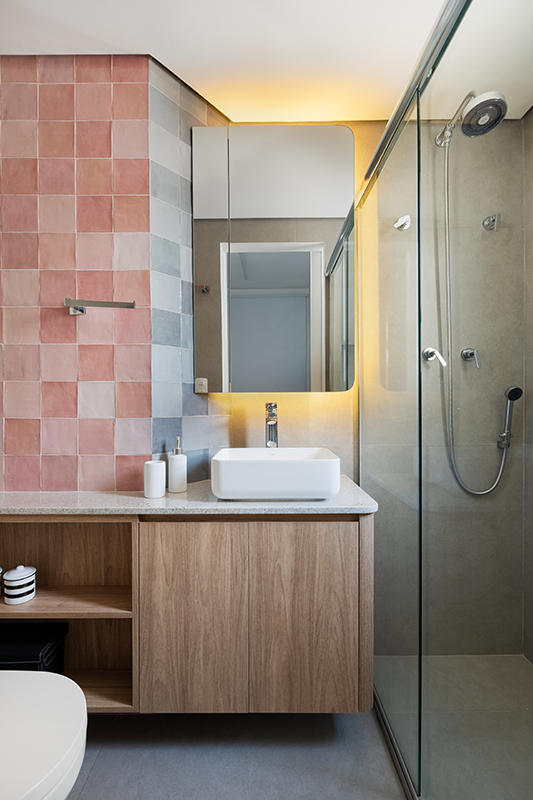 Projeto: Studio Monfré | O banheiro recebeu azulejos em tons de rosa combinando perfeitamente com o revestimento cinza escolhido para o piso. 