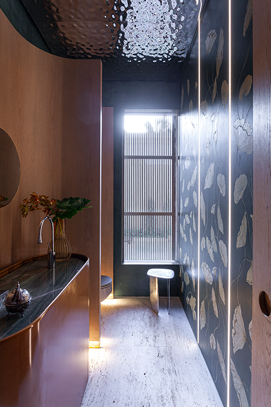 Projeto: BZP Arquitetura | Lavabo com teto em inox “water ripple”, pintura artística e painéis curvos de madeira, traduzindo sofisticação e personalidade.