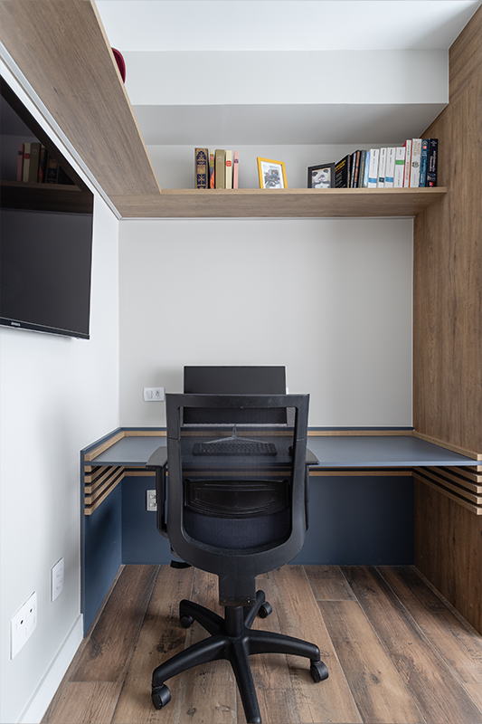 Projeto: Camila Palladino| Suíte funcional com home office: marcenaria contínua organiza bancada, armários e nichos; paleta em azul profundo, cinza e branco traz leveza e foco