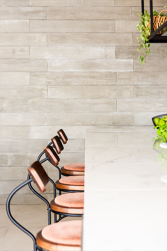 Projeto BMA Studio | Na parede revestida de placas de concreto, spots embutidos no piso entregam um jogo de luz e sombra que realçam os detalhes do revestimento cimentício empregado pelo arquiteto Bruno Moraes 