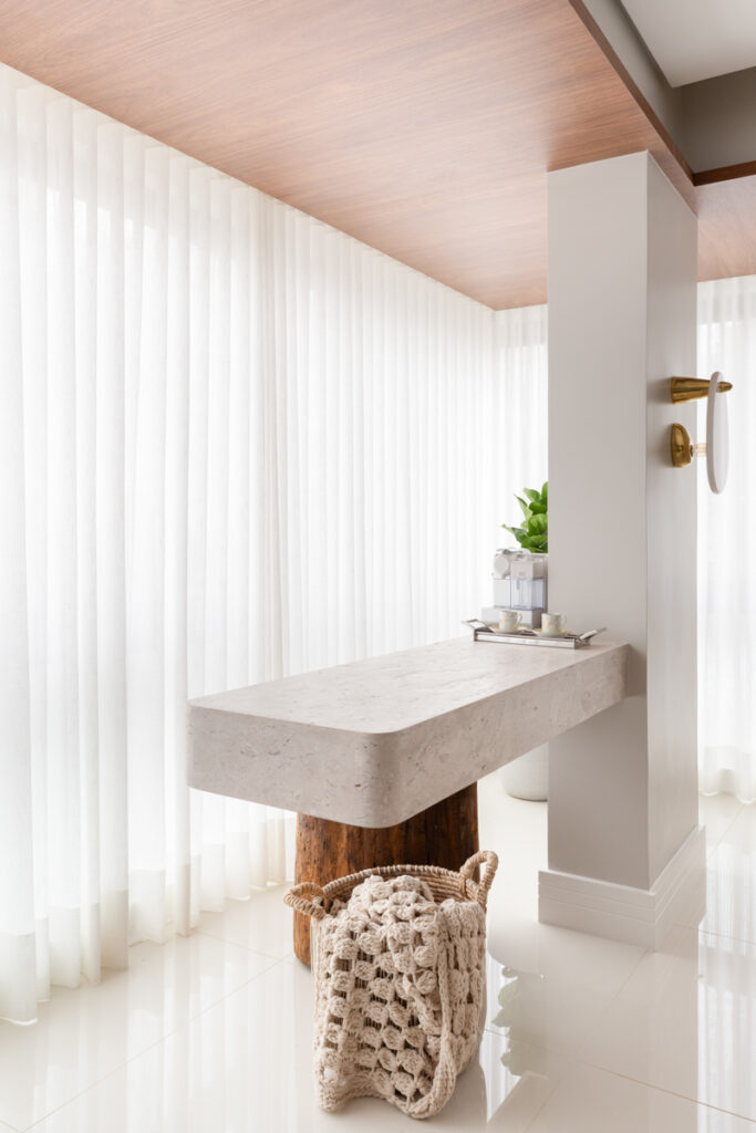 Projeto: Sabrina Salles | Elemento estrutural transformado em cantinho multifuncional, com bancada suspensa ideal para cafés e apoio em jantares.