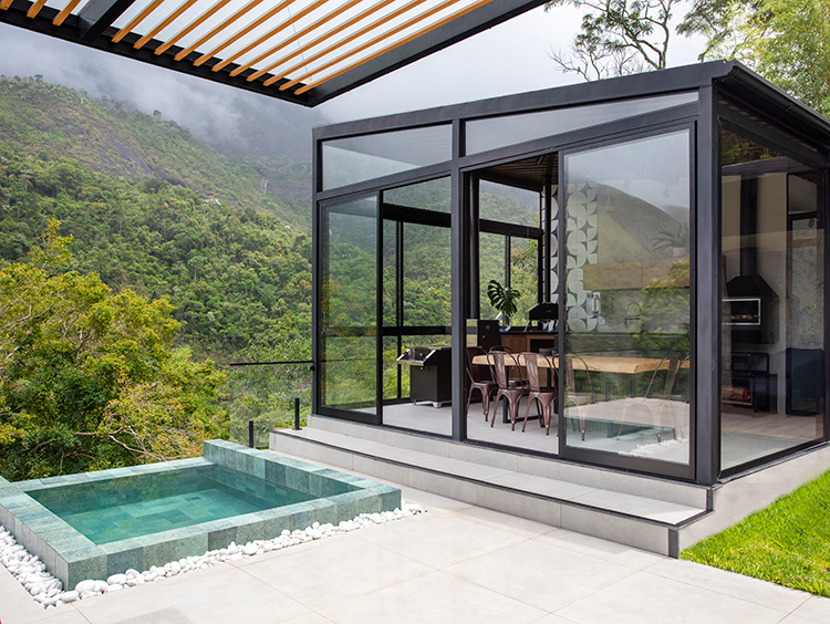 Projeto: Felipe Rohen Arquitetura | A piscina compacta, com borda infinita e aquecimento solar, cria atmosfera de spa em meio às montanhas.