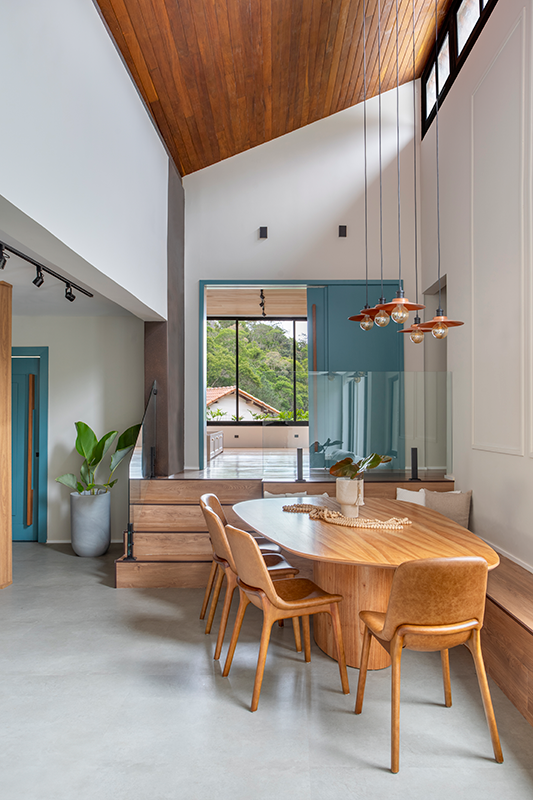 Projeto: Felipe Rohen Arquitetura | As janelas amplas de peitoris baixos emolduram a vista da serra, conectando interior e paisagem, enquanto o banco baú aproveita o desnível para contemplação.