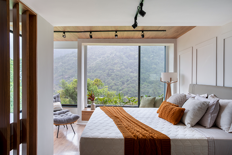 Projeto: Felipe Rohen Arquitetura | A suíte do casal ganhou atmosfera de hotel, com banheiro integrado, porcelanato azul e um delicado canteiro de seixos que reforça o vínculo com a natureza.