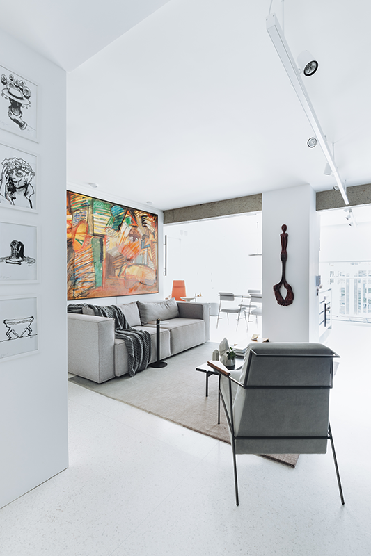 Neste apartamento assinado pelo arquiteto Raphael Wittmann, um detalhe chama atenção logo de cara: a obra de arte colocada na parede onde está o sofá