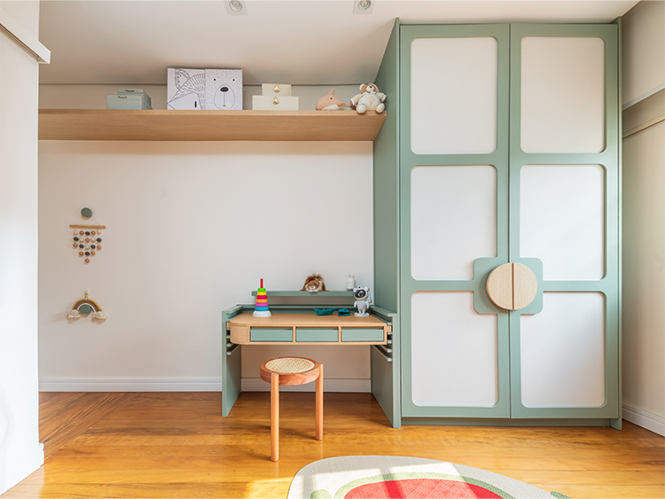 A estrutura do quarto conta com uma cama com grade, baú de brinquedos e uma escada que leva o menino ao nível superior. A escrivaninha conta com regulagem de altura que acompanhará seu crescimento