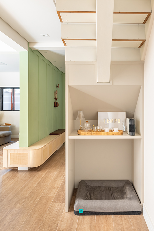 Em zoom nas imagens, a marcenaria curva se repete em todo o projeto. Sob os degraus, além de um armário embutido para organizar os brinquedos da criança, um nicho especial para a caminha do cachorro foi integrado ao cotidiano da casa de forma natural e discreta