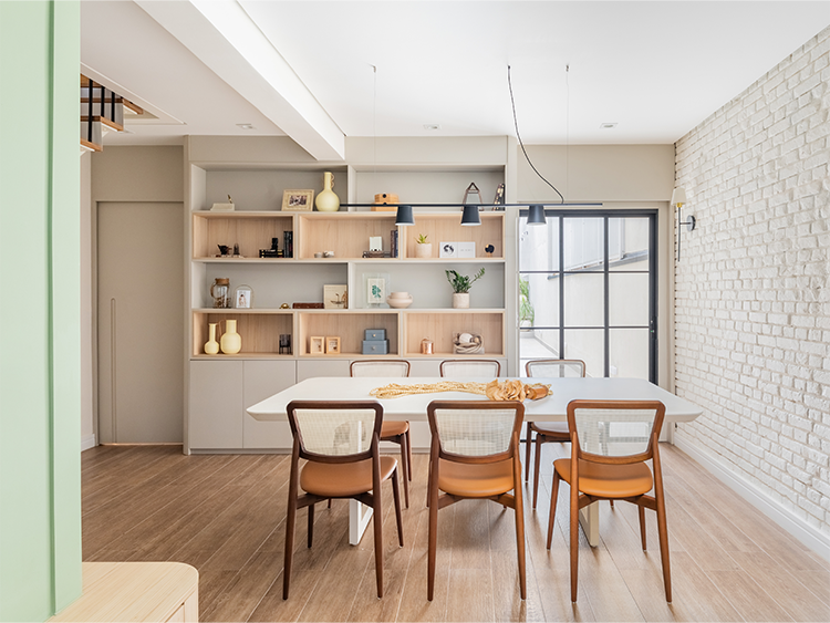 Na execução do projeto assinado pelo arquiteto Bruno Moraes, a parede de tijolinhos aparentes, que já existia na edificação, carrega uma história à parte: o desejo dos moradores era repetir o acabamento em outros ambientes, mas limitações técnicas exigiram soluções de infraestrutura elétrica e a recomposição manual de alguns tijolos