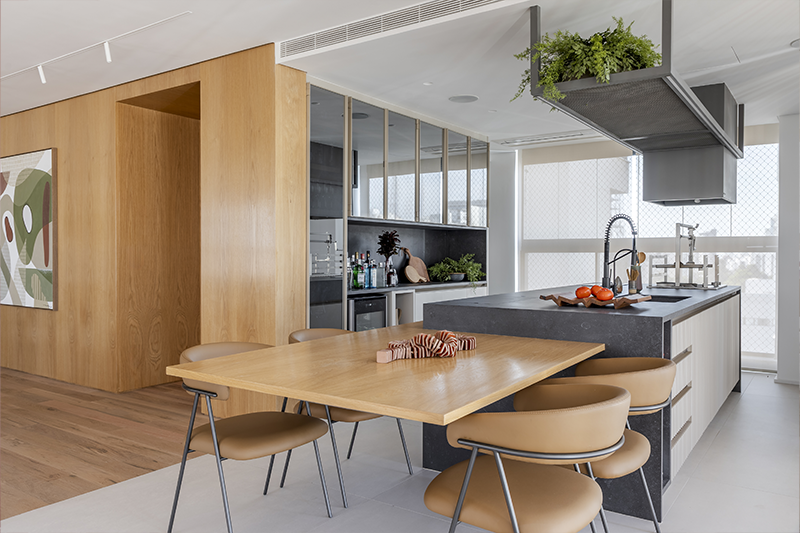 Uma mesa embutida de forma flutuante na ilha serve tanto para refeições rápidas no dia a dia quanto para ocasiões festivas