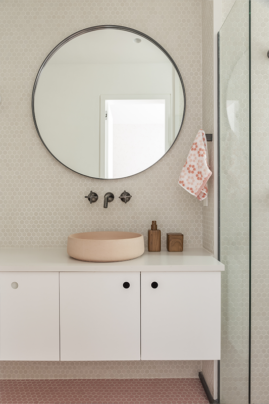 Nos banheiros, os revestimentos hexagonais feitos à mão pela Keramika refletem as cores escolhidas pelas crianças. No dele, pastilhas artesanais azuis e metais em grafite escovado. No dela, pastilhas e cuba de concreto pigmentado em tom rosado