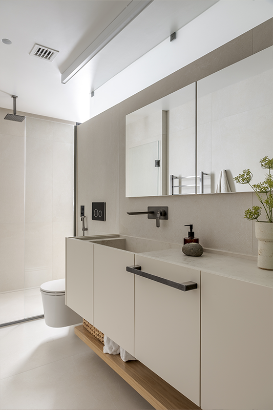 Um lado para ele e outro para ela reforçam as características de cada um. E, como solução para roupas sujas, o escritório projetou um cesto de roupas em marcenaria (imagem à direita)