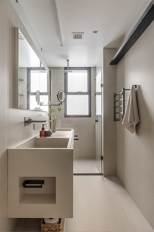 Um lado para ele e outro para ela reforçam as características de cada um. E, como solução para roupas sujas, o escritório projetou um cesto de roupas em marcenaria (imagem à direita)