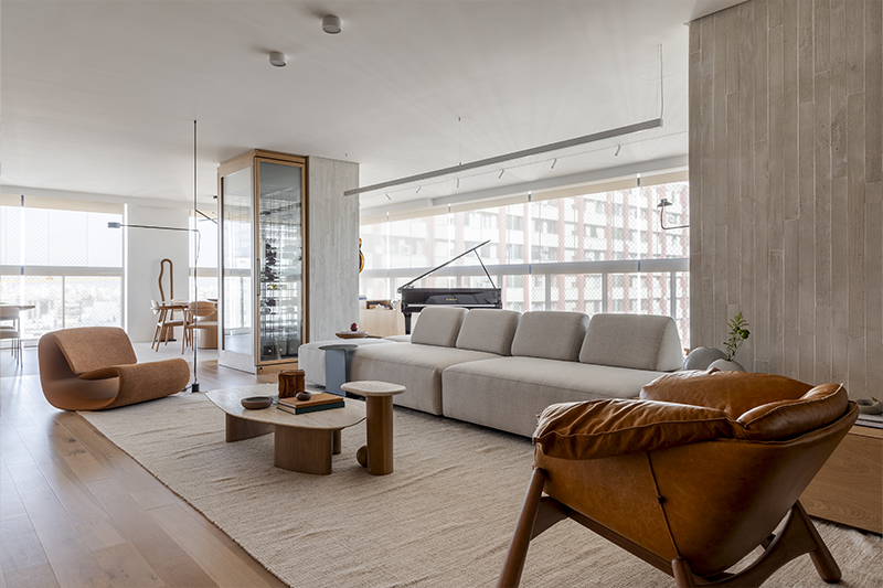 A marcenaria advém do hall e segue em painéis contínuos que acomodam uma pintura exclusiva de Ronald Lago