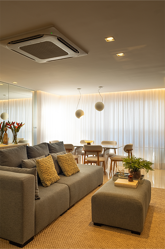 O sofá no centro organiza e conecta: estar, jantar e área gourmet se encontram em um layout fluido e funcional.