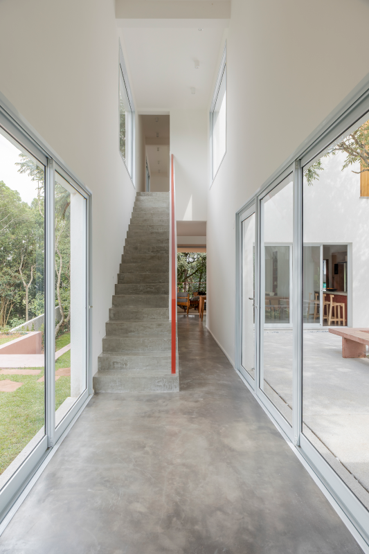 Um dos destaques dessa passagem está no guarda-corpo desenhado pelo arquiteto Raphael Wittmann, de linhas retas e pintado em um tom terracota que reafirma a paleta de cores da casa