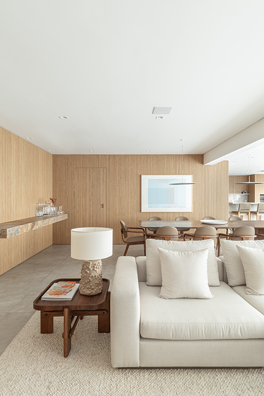 Living amplo e integrado, onde a marcenaria em freijó desenha ritmo e continuidade entre os espaços