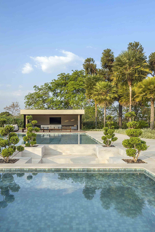 Outros ângulos da área de lazer destacam as piscinas, protagonistas dos dias de descanso, envoltas por um paisagismo que cria uma atmosfera natural e acolhedora.
